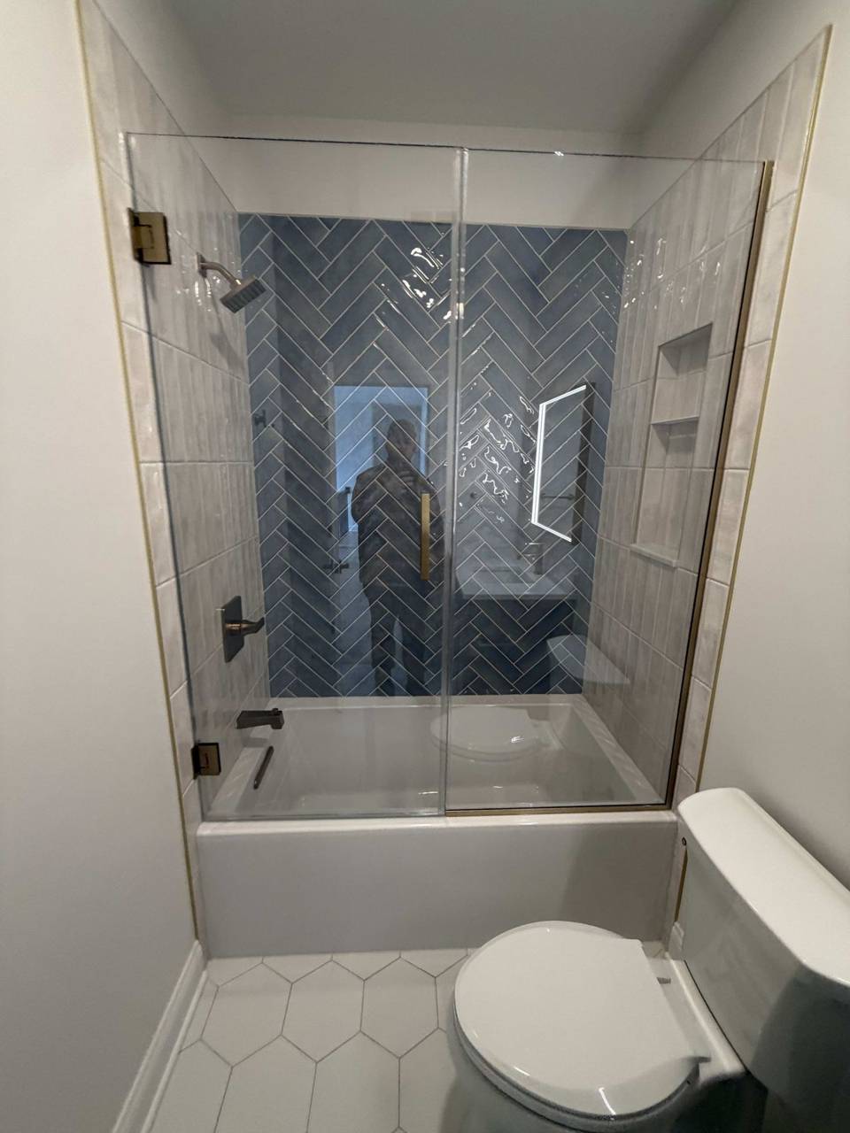 Remodeled bathroom with herringbone tile shower