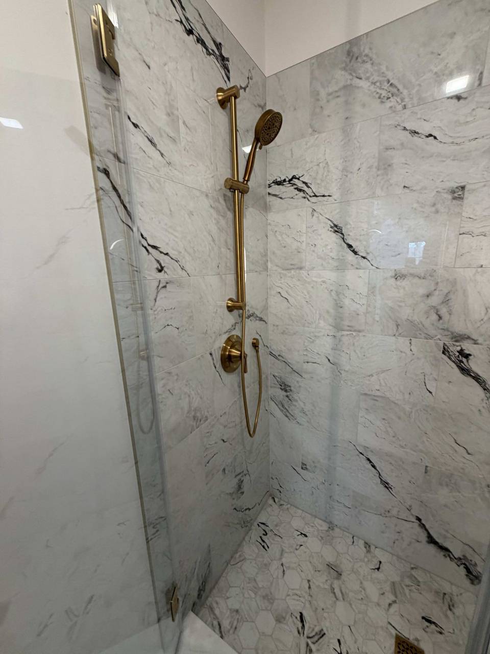 Marble shower with brass fixtures