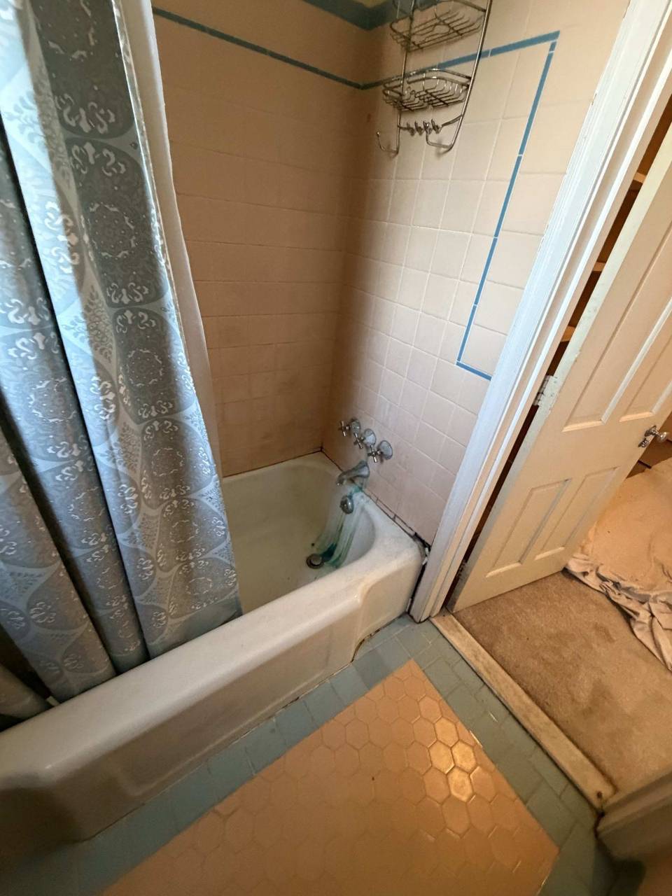 Bathroom before remodel — pink tile tub area