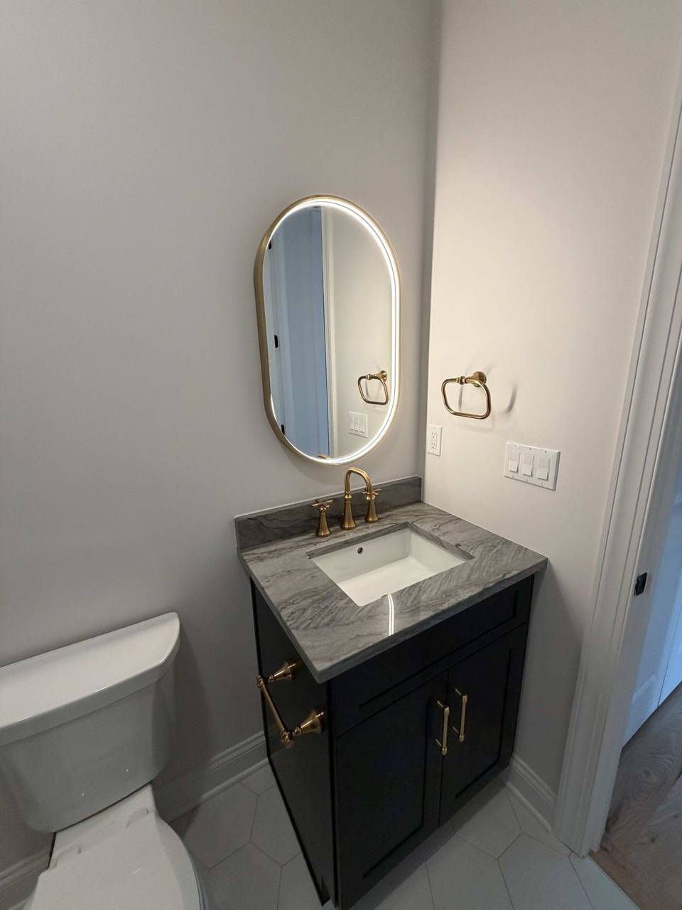 Powder room with oval mirror