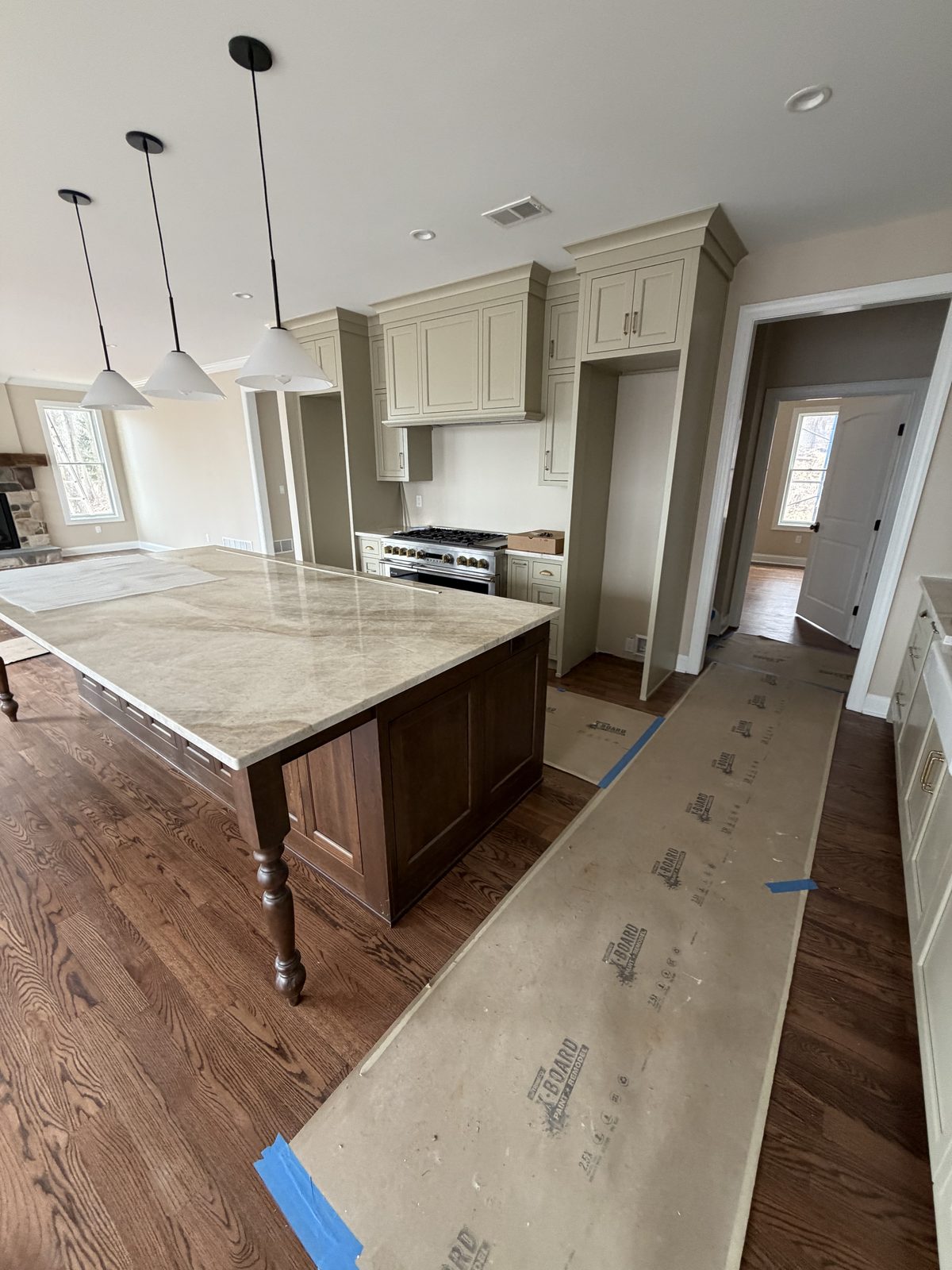 Cream kitchen island with stone countertop and pendant lights